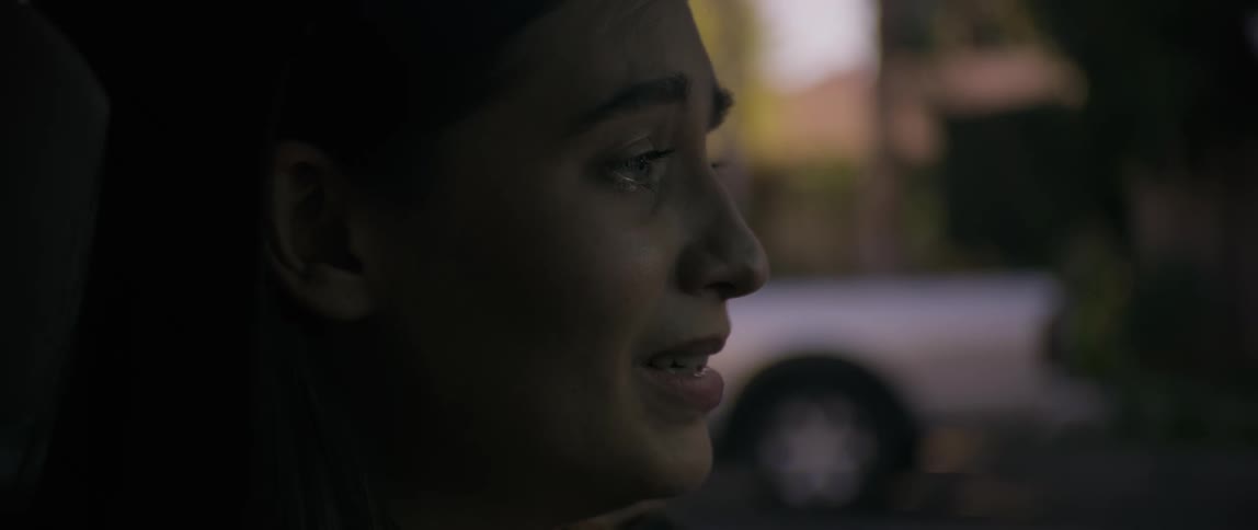 A woman crying while sitting inside a car