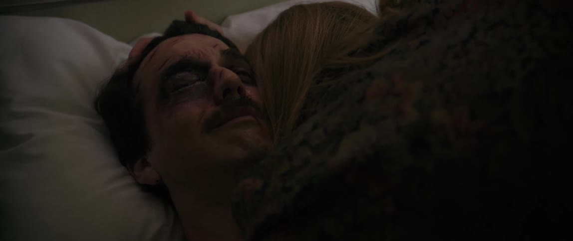 A woman caresses and hugs a crying hospital patient