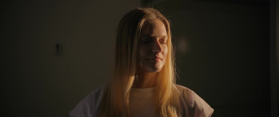 A woman is smiling as the sunlight finally hits her face