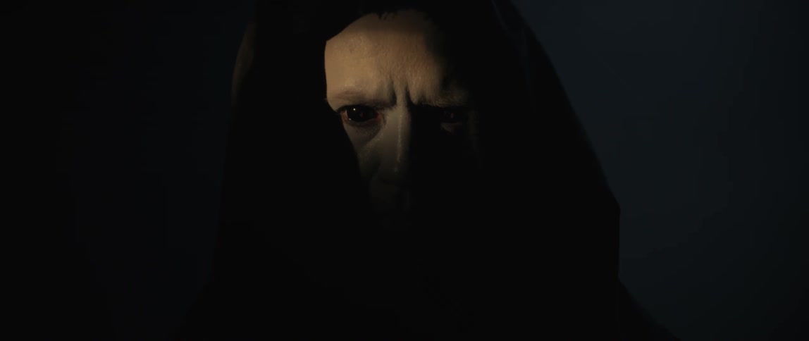 Hooded person with wide eyes in a dark room
