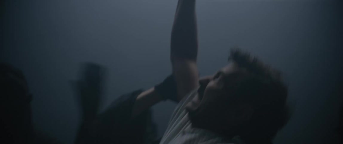 A man is being attacked in the fog by people in black robes
