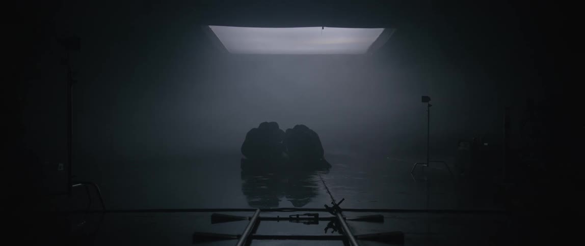 A group of people falls to their knees in a dark room