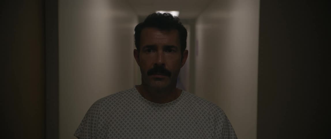 Male patient standing in a corridor turns to look as the lights go out