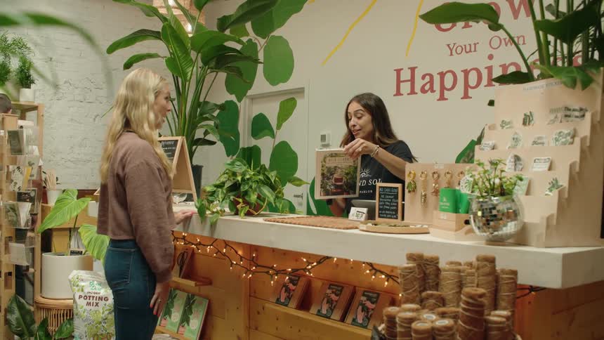 A woman purchases a plant in the shop