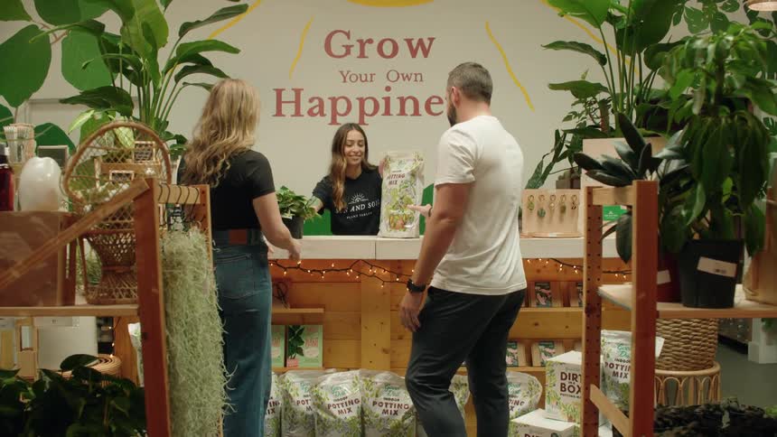 Customers walking to counter purchasing plant and soil at a plant store