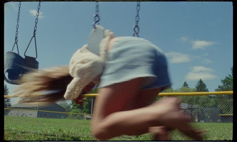A girl is having fun while spinning on a swing