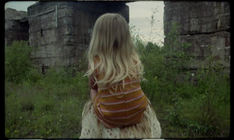 An older sister playfully carrying the younger sister on her shoulders while the child is scared and crying