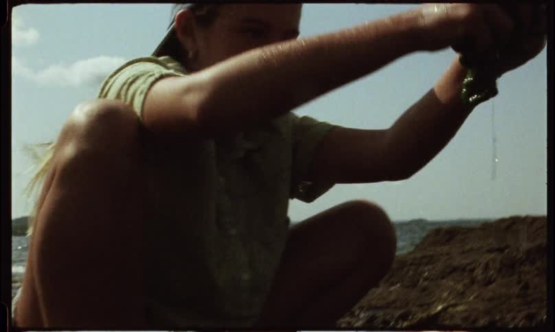 Two small children playing with seaweed