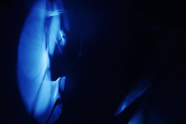 A bright blue light in a dark environment moving randomly