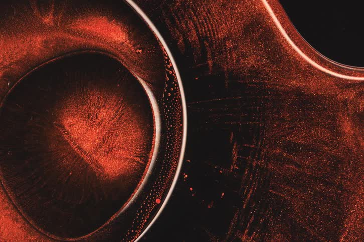 The crimson ink color moves in waves