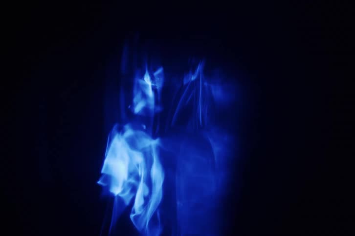 An abstract smoky texture object of bright blue color moving on black background