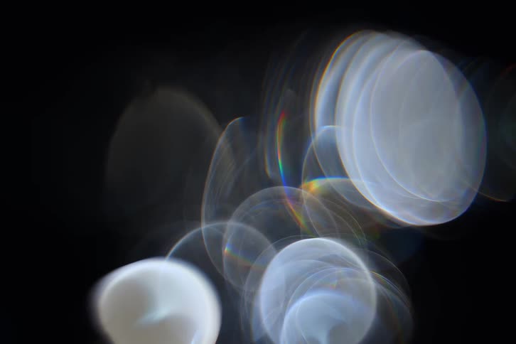 Several white light flares of different shapes on a black background