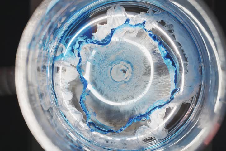 The blue and clear ink moves slowly