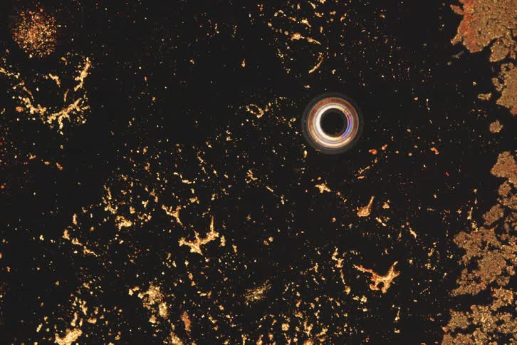 Gold particles float in the flowing ink