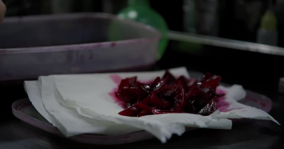 A woman spoons food out of the container with liquid