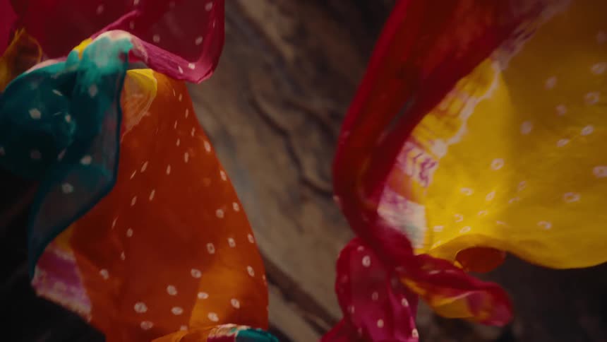 Colorful fabrics float and swirl in slow motion creating a vibrant and dynamic visual display