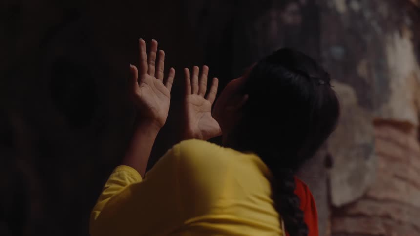 Woman raises her hands in a pose of supplication