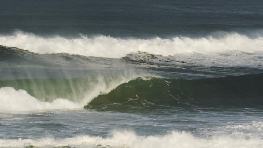 Waves splash and curl as they roll into shore