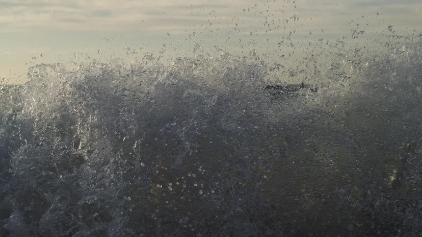 A wave crashes into the shoreline