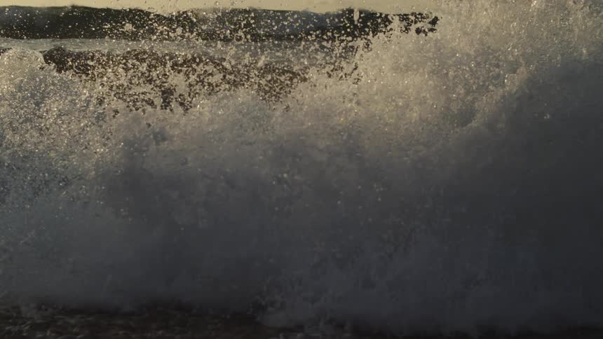 A large wave moves along on the beach
