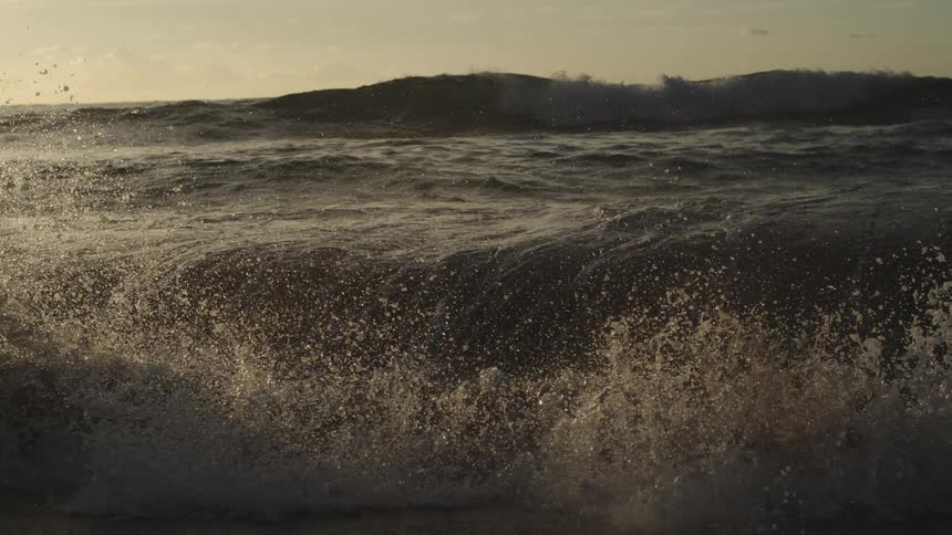 Waves splash into the air and sparkle as they roll in to shore