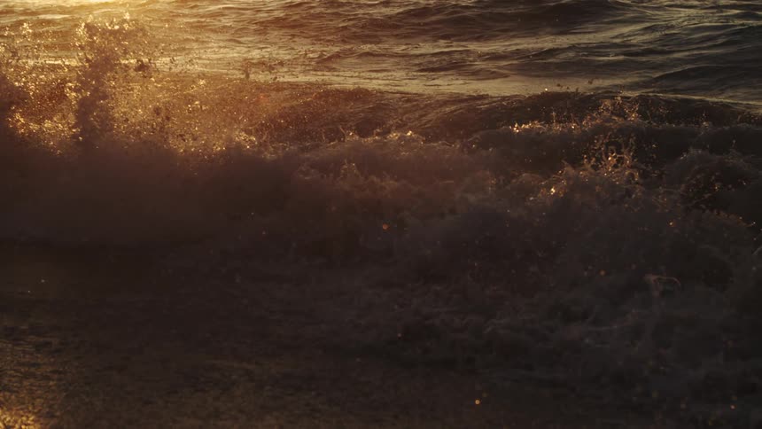 A wave crashes onto a sandy beach