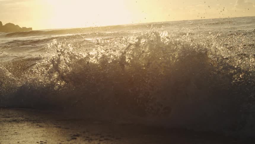 Waves flow onto the beach at sunrise
