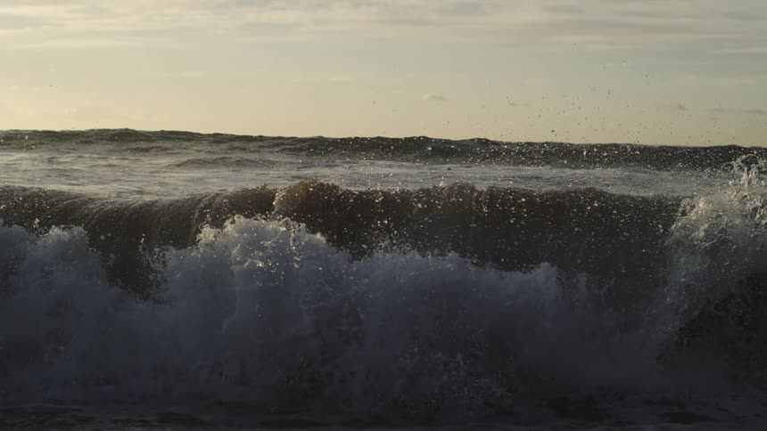 Wave forms and splashes on the shore at dusk