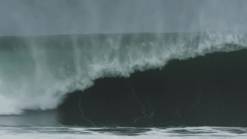 A surfer surfs through a wave