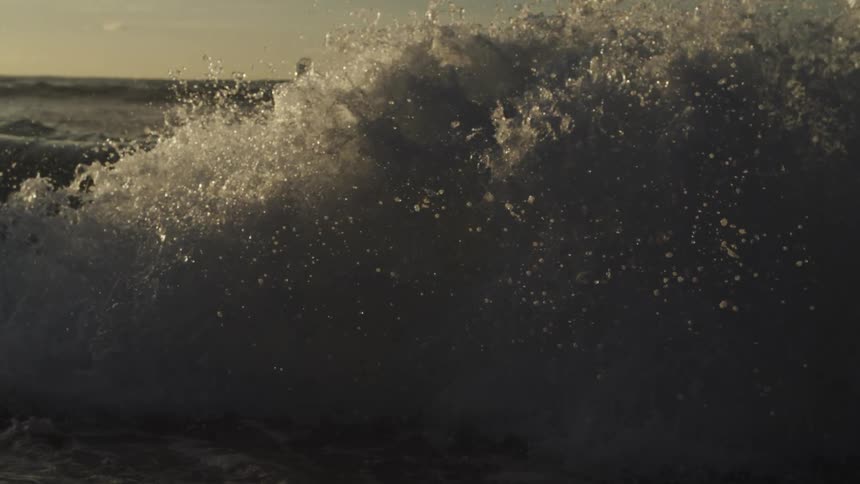 Waves splash and foam as they roll into shore