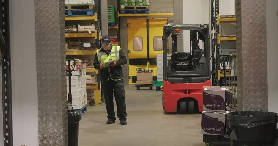 Man taking notes inside a logistics center