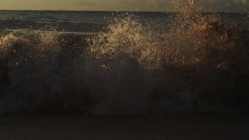 Mist flies from the crashing wave on the beach