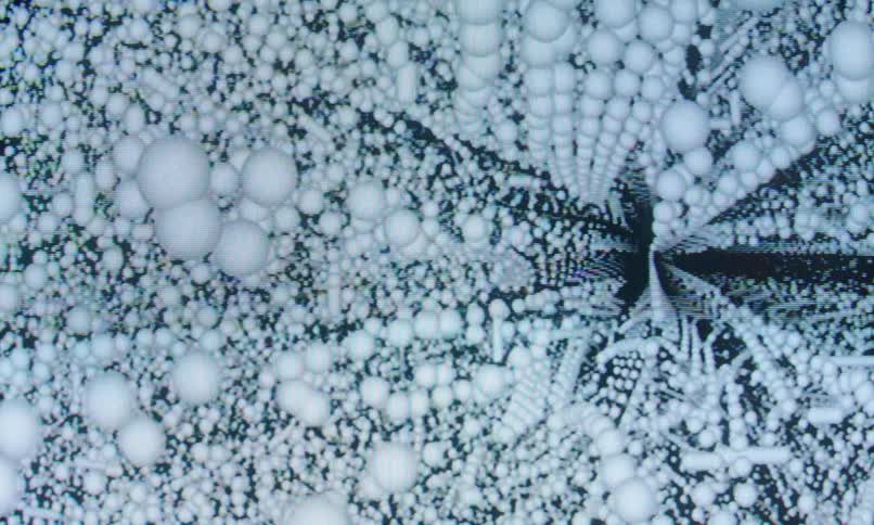 White balls patterned in an abstract infinity loop against a black background