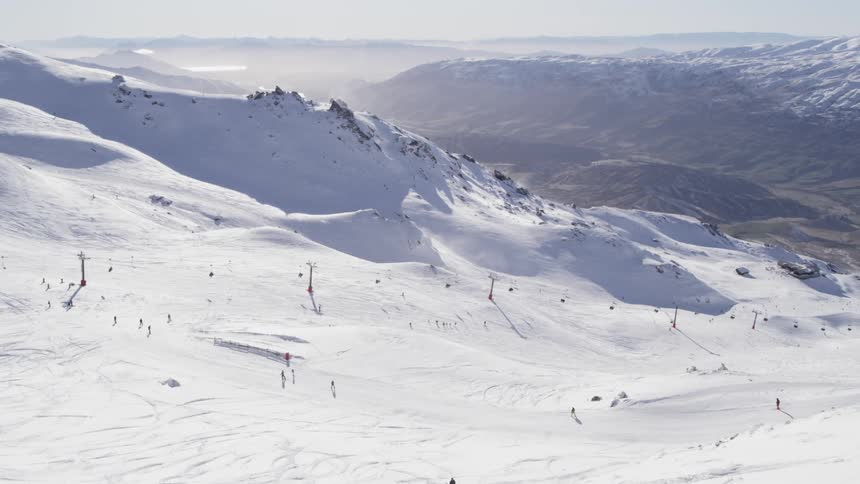 Skiers descend a snowy mountain