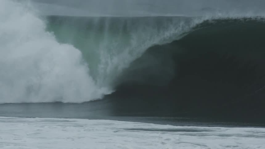 Slow motion of surfer riding inside a large tubular wave