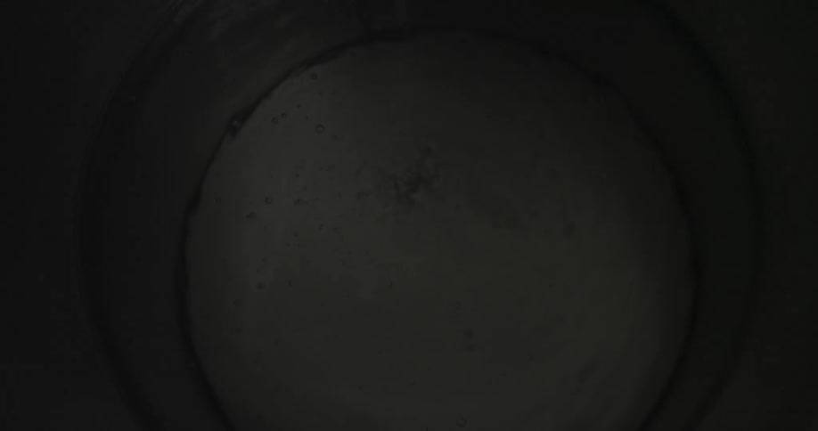 The water is shaking in this dark pool giving off bubbles