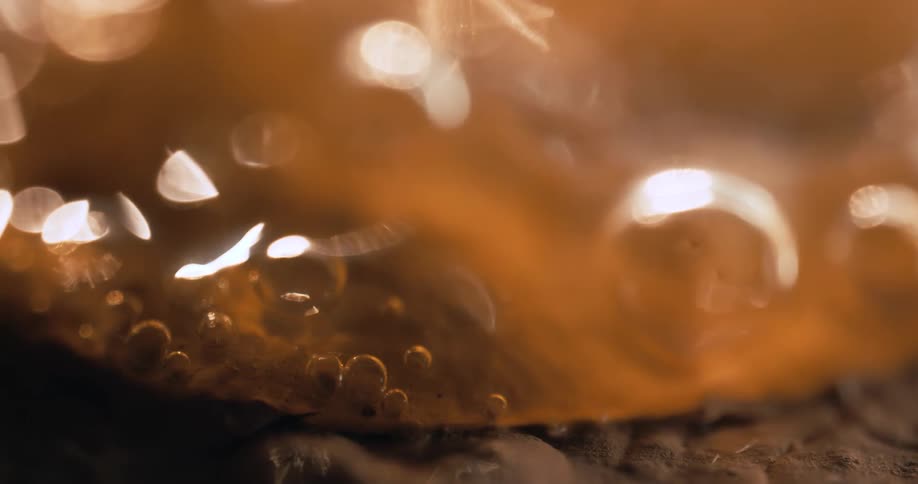 Close up of a bottle with liquid and bubbles popping