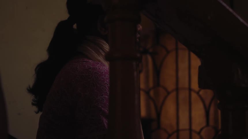 A woman looking sad sitting on a wooden staircase