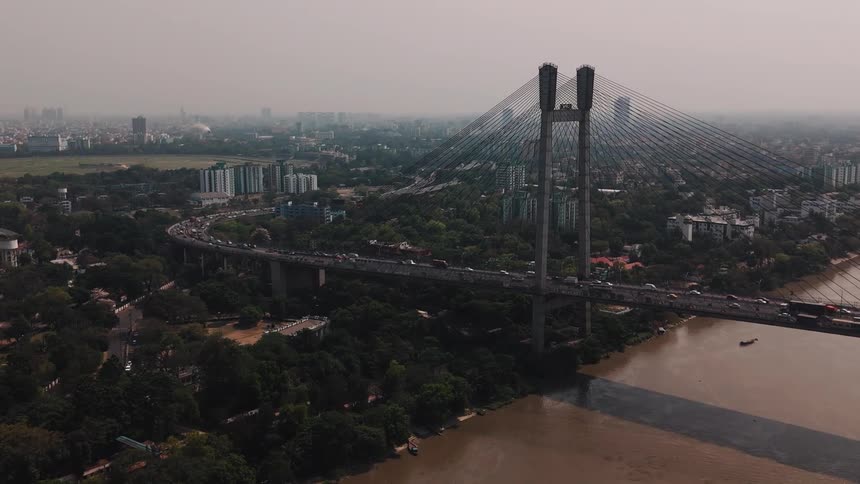 Heavy traffic is traveling on the bridge going to the city