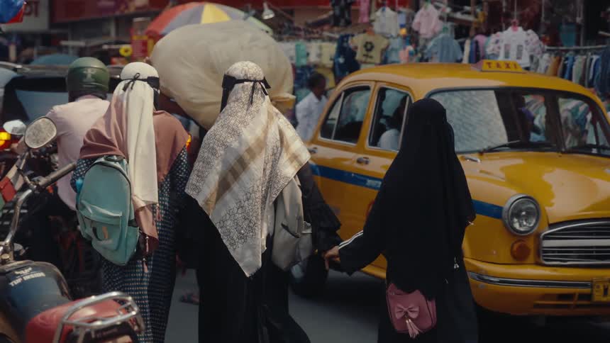 Pedestrians and vehicles travel by the market
