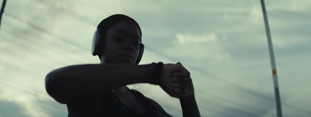 Black woman nods and smiles after looking into her smartwatch