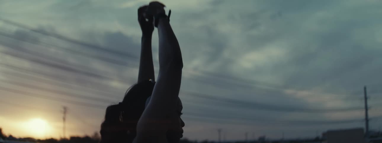 Woman outdoors stretching her arms at sunrise