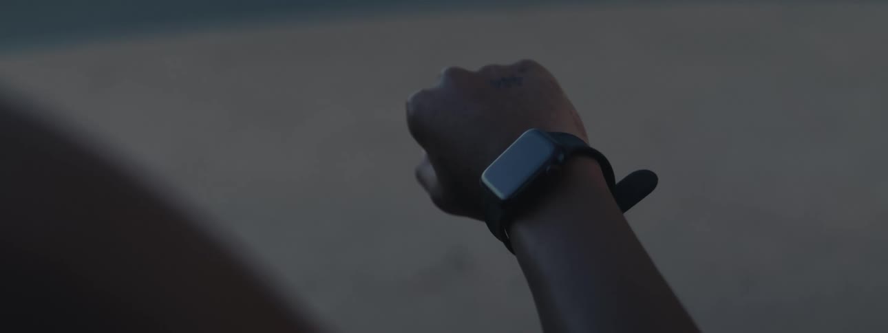 A person checks their smartwatch while outdoors possibly preparing for or tracking a workout