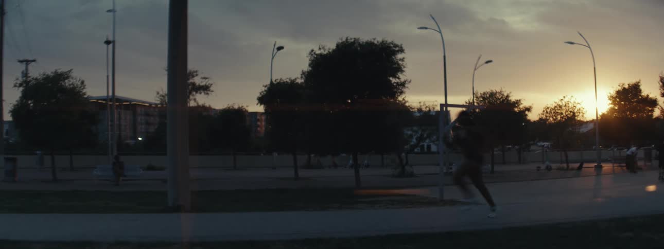 Woman running in a park under a sunset in the city