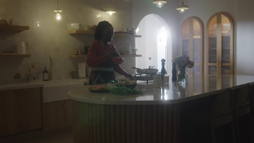 Cheerful woman in the kitchen cooking