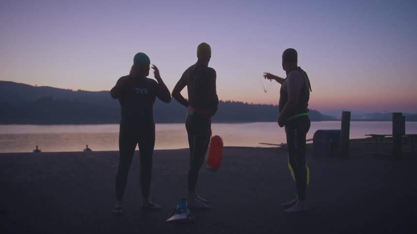 Three divers getting ready and talking before entering the water