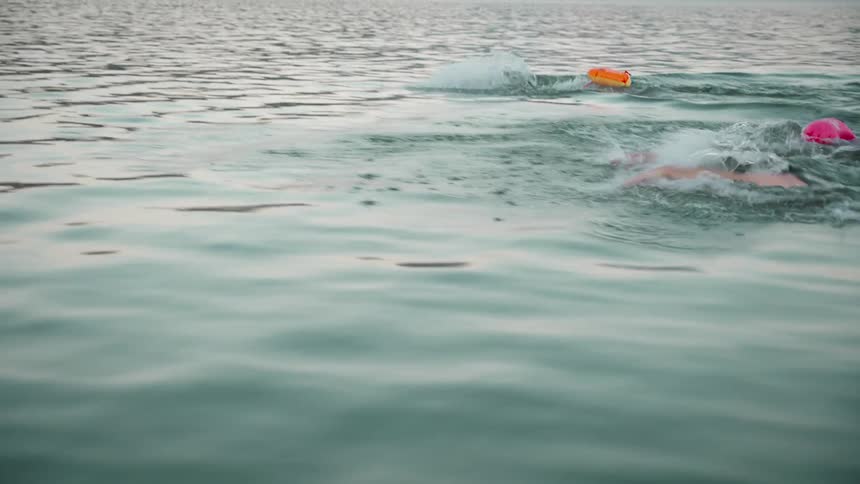 Men are racing as they swim in the water