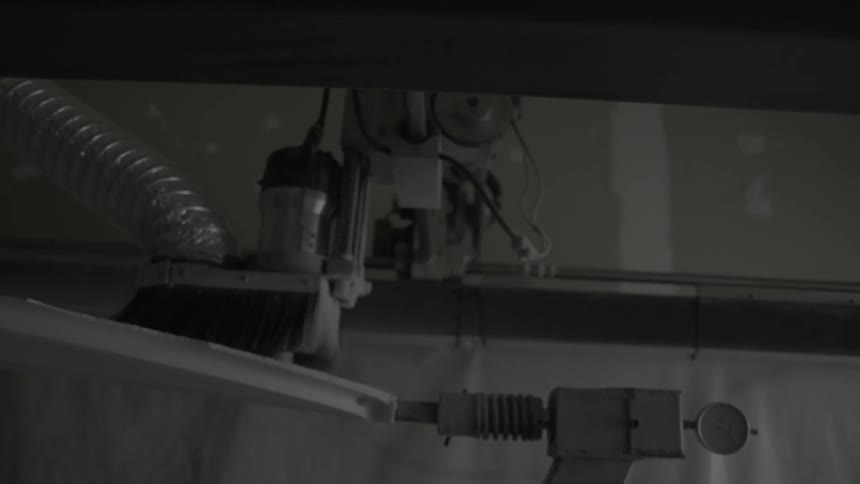A machine is painting a board on a lever