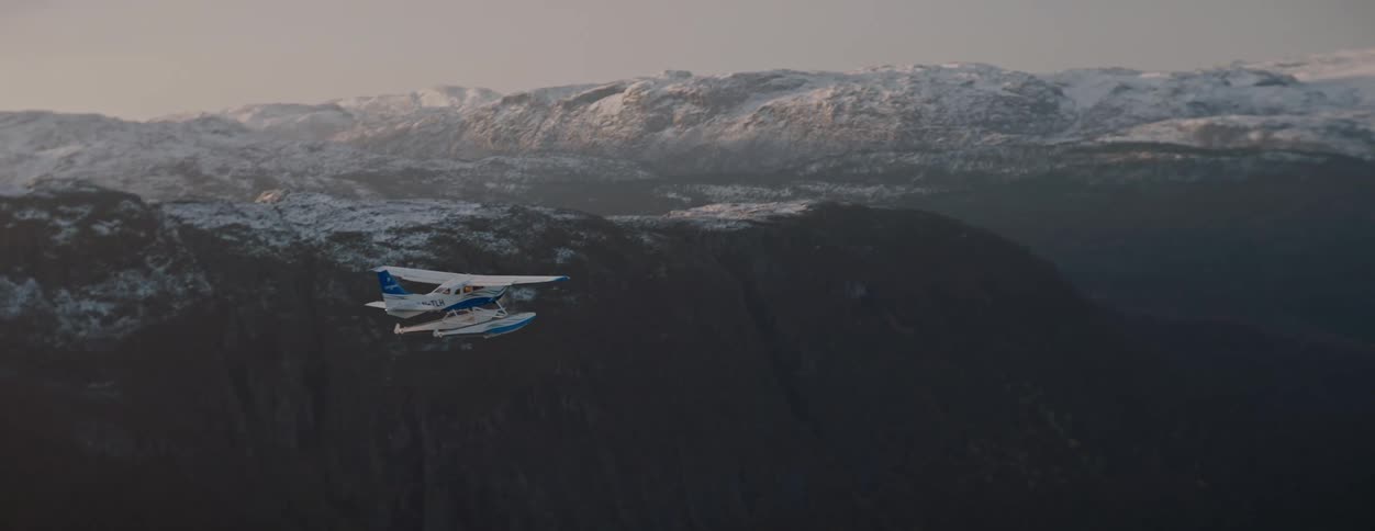 Single engine plane flying near snowy mountains