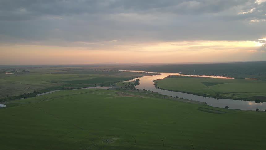 The landscape is flat green land with a river running through it
